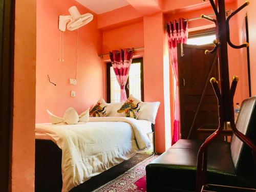 een slaapkamer met oranje muren en een bed en een raam bij Shristi Hotel & Lodge in Bandipur