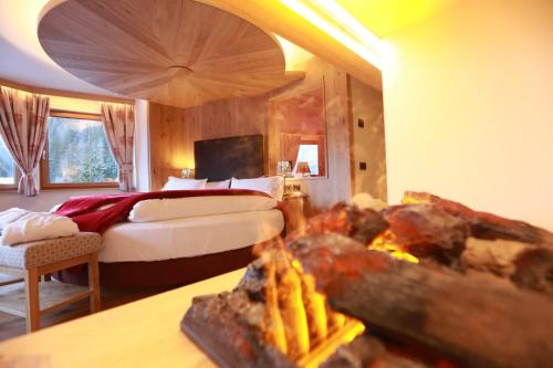 a hotel room with a bed and a fireplace at Hotel Cesa Tyrol in Canazei