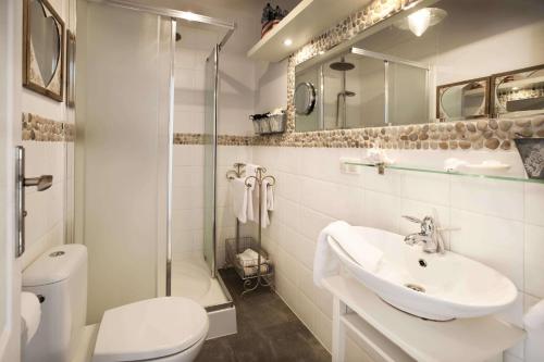 a white bathroom with a sink and a toilet at Fisher House in Sopot