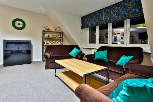 a living room with two couches and a coffee table at Hotel Wiosna in Rabka-Zdrój