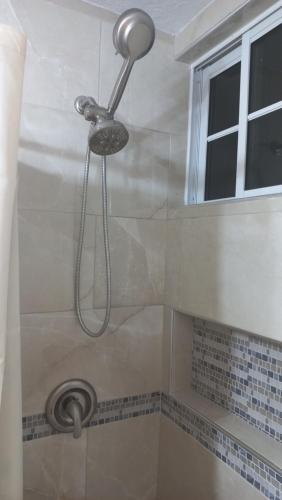 a shower with a shower head in a bathroom at Beach Studio 20 in Ocho Rios
