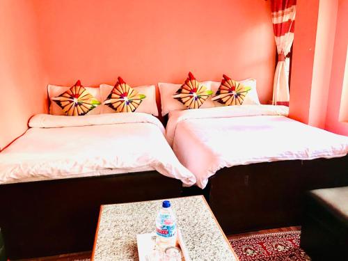 a room with two beds and a table with a water bottle at Shristi Hotel & Lodge in Bandīpur
