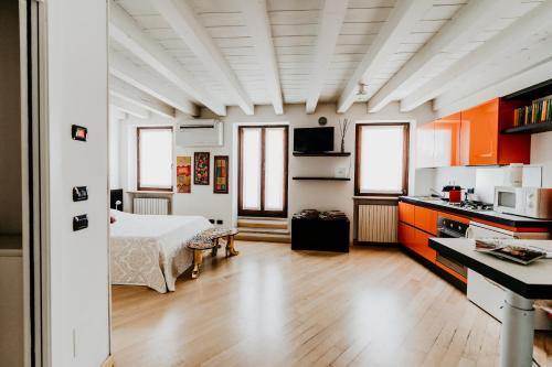 a room with a bed and a kitchen with orange cabinets at La Piu' Bella Verona in Verona