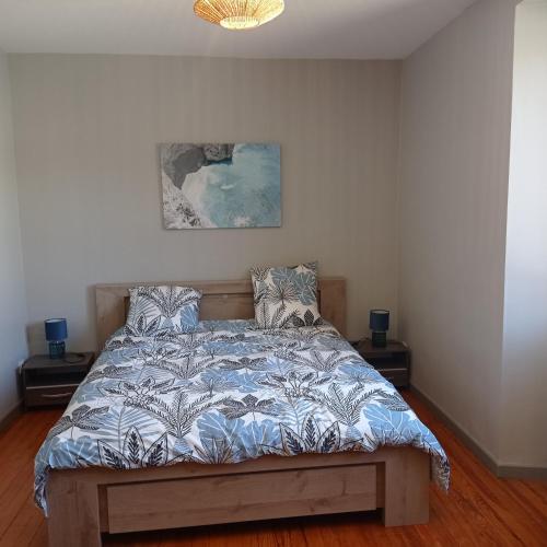 une chambre avec un lit avec une couette bleue dans l'établissement Agréable maison de village à coté de la DOLCE VIA, à Saint-Sauveur-de-Montagut