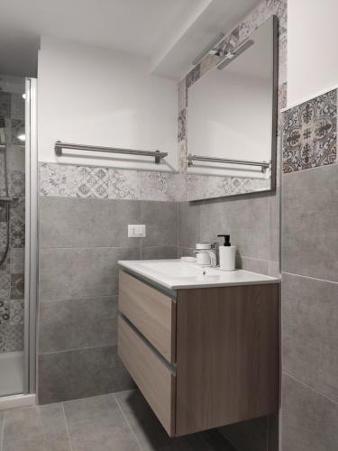 ein Bad mit einem Waschbecken, einer Dusche und einem Spiegel in der Unterkunft Il Vicoletto in Pisticci
