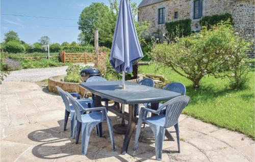 une table et des chaises avec un parasol sur une terrasse dans l'établissement Beautiful Home In St, Pierre Langers, à La Lucerne-dʼOutremer