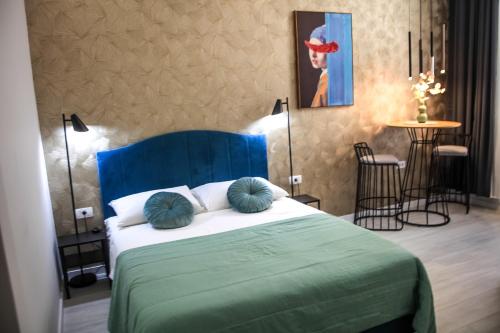 a bedroom with a blue bed with pillows on it at Hedone City Luxury Apartments with FREE PARKING in Pula