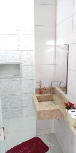 a white bathroom with a sink and a tub at Pousada Rosa de Saron in Holambra