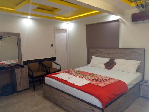 a bedroom with a bed with a mirror and a dresser at Pearl Cottage Guest House in Karachi