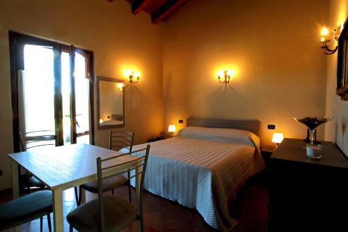 a bedroom with a bed and a table and a window at B&B Cascina Quaderna in Castenedolo