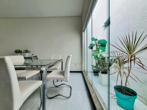 uma sala de jantar com uma mesa de vidro e algumas plantas em Caminho das Águas do Chico em Canindé de São Francisco