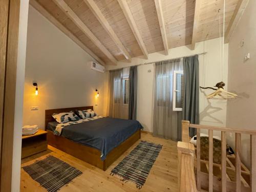 a bedroom with a bed and a window and a staircase at Anastasia’s Apartment in Sinarádes