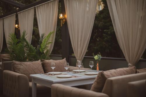a table with wine glasses on a patio with curtains at Grand Hotel Baku Central Park in Baku