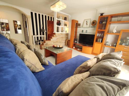sala de estar con sofá azul y TV en Apartamentos Ambitus Active, en Sanxenxo