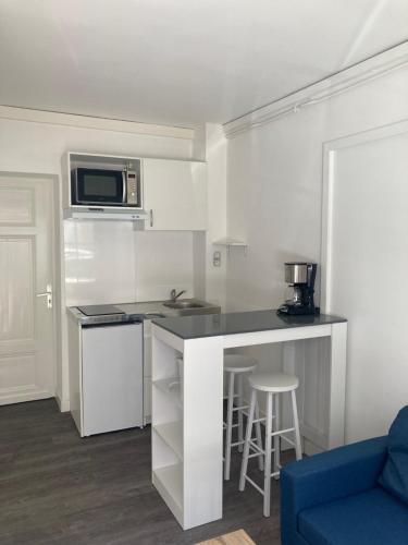 une petite cuisine avec un comptoir et un canapé bleu dans l'établissement Le Rouget de Lisle proche gare, à Agen