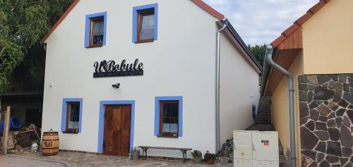 a white building with a sign on the side of it at Vinný sklep a penzion U Bobule in Louka