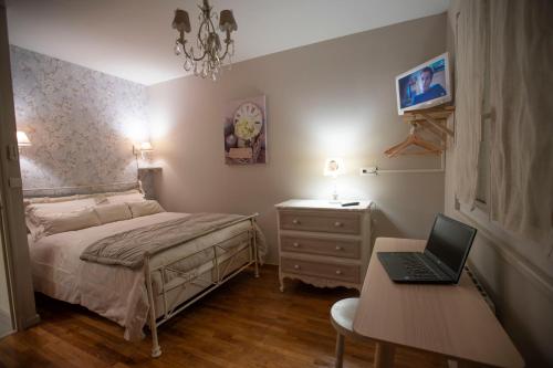 a bedroom with a bed and a laptop on a desk at Chambre de Charme dans maison d'hote "Le Petit Clouet" - Rochecorbon in Rochecorbon