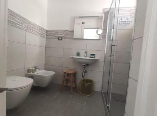 Baño blanco con lavabo y aseo en Ninfea Tropea City Rooms en Tropea
