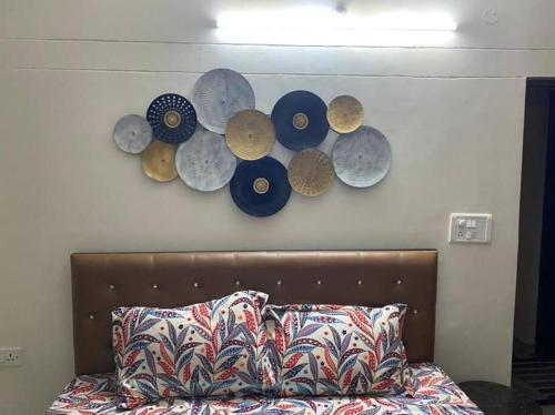 a group of plates on a wall above a bed at Shivalaya cottage,Home away from home,mehragaon,bhimtal in Bhowāli