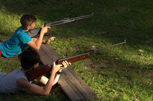 two young boys playing with a toy gun on a picnic table at SELMENT RESORT Mazury in Ełk