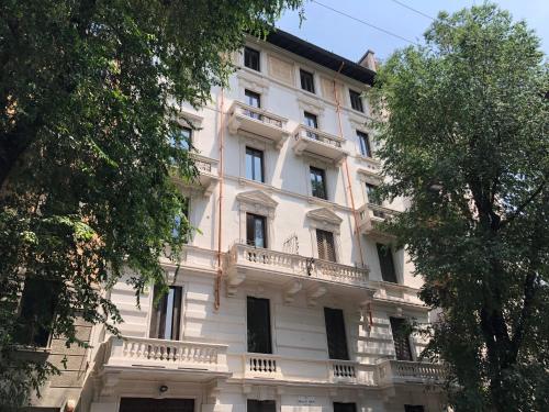 ein großes weißes Gebäude mit Balkon in der Unterkunft Sant'Ambrogio with charme in Mailand