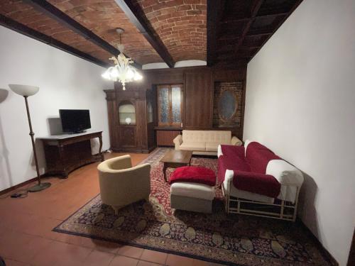 sala de estar con sofá, sillas y TV en Agriturismo Poderi Zunino, en Ponti