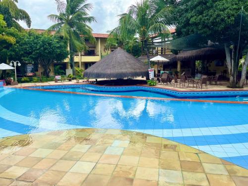 ein großer Swimmingpool mit einem Resort mit Bäumen und Stühlen in der Unterkunft Apartamentos no Solar Pipa in Pipa