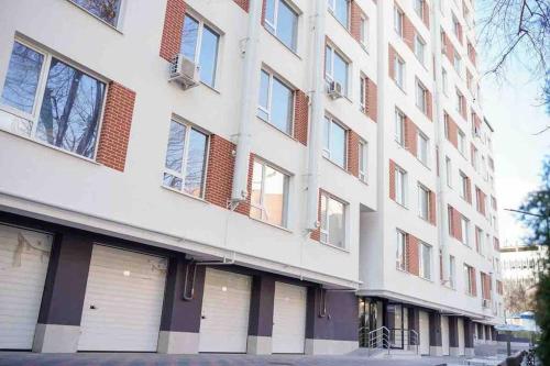 a tall white building with windows on a street at RentWill apartments Loft in Chişinău