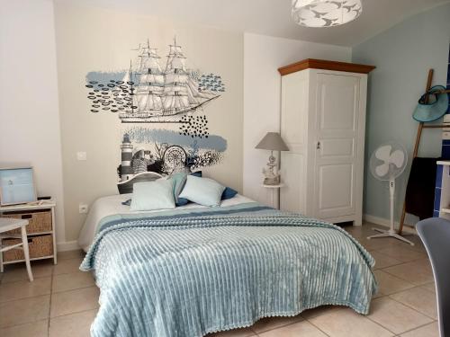 a bedroom with a bed with a ship on the wall at La Sornière in Talmont