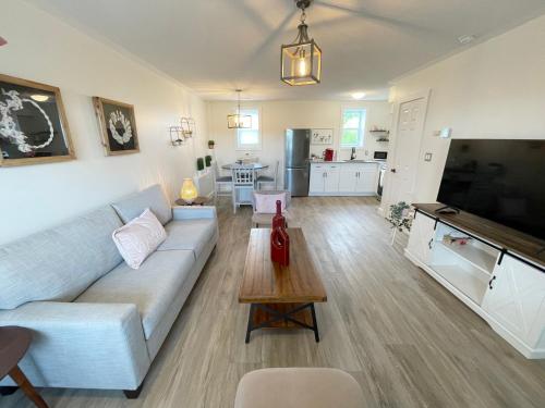 a living room with a couch and a table at Gateway to Greenwich Suites in Saint Peters