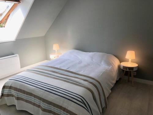 ein Schlafzimmer mit einem Bett mit zwei Lampen an zwei Tischen in der Unterkunft Appartement Duplex Perros Guirec 4 pièces 8 personnes in Perros-Guirec