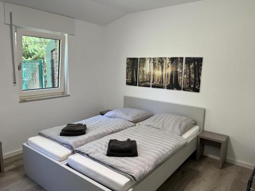 ein weißes Schlafzimmer mit einem Bett mit zwei schwarzen Säcken darauf in der Unterkunft Luxus Apartment III - Garten, Küche, Gym in Reken