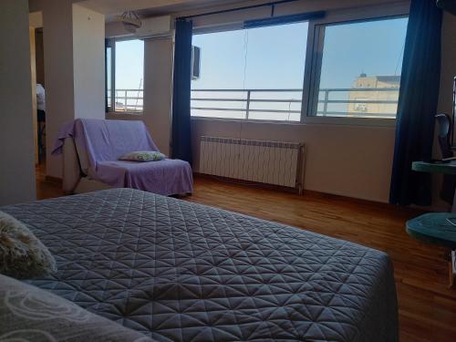 1 dormitorio con 1 cama y 2 ventanas grandes en Studio Mali Zmaj, en Belgrado