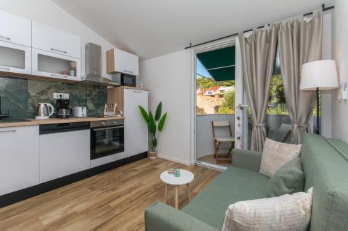 een woonkamer met een groene bank en een keuken bij Apartment Rivendell in Dubrovnik