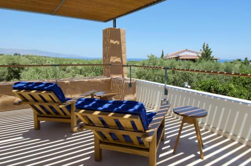 a porch with two chairs and a stool on a deck at Conte Marino Villas in Maleme