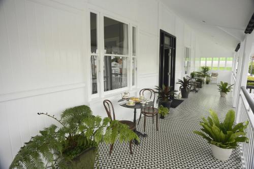 a porch with a table and chairs and plants at Heal House in Brisbane
