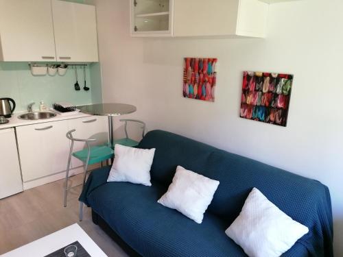 a living room with a blue couch and a kitchen at Studio Central Park in Cannes