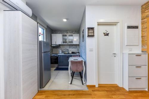 a kitchen with a refrigerator and a table in it at Relax studio apartman Novi Sad, Telep in Pasuljište
