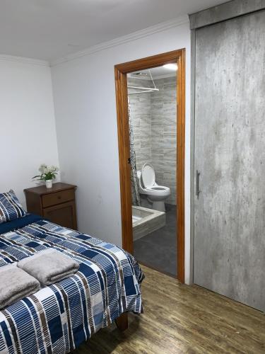 a bedroom with a bed and a bathroom with a toilet at Apart Hotel Vicencio Iquique in Iquique