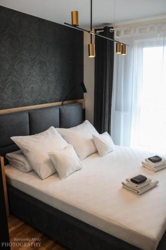 a bedroom with a large bed with white pillows at D Apartments Centrum Prowiantowa II in Białystok