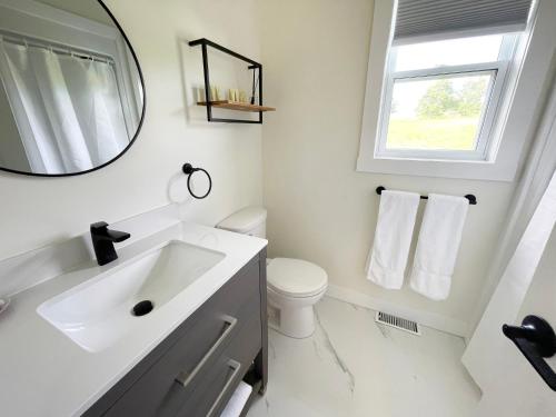 a white bathroom with a sink and a mirror at Gateway to Greenwich Suites in Saint Peters