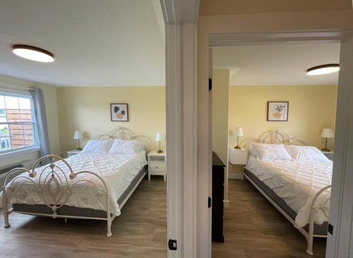 a bedroom with two beds and a mirror at Gateway to Greenwich Suites in Saint Peters