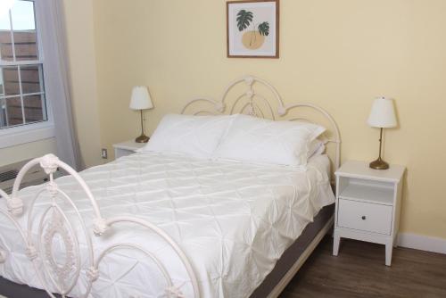 a bedroom with a white bed with two night stands at Gateway to Greenwich Suites in Saint Peters