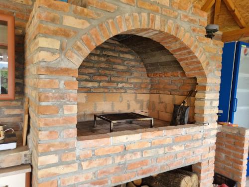 un horno de ladrillo con un banco en su interior en HOOPOVO HOUSE Fruška gora, en Irig