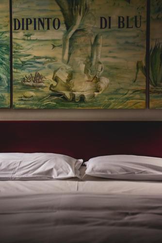 a painting above a bed in a bedroom at Damaranto Residenza e Cucina in Soave