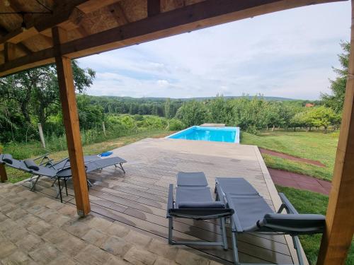 a wooden deck with chairs and a swimming pool at HOOPOVO HOUSE Fruška gora in Irig