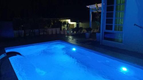 a swimming pool at night with blue lights at Beit Azzahra in Kuantan