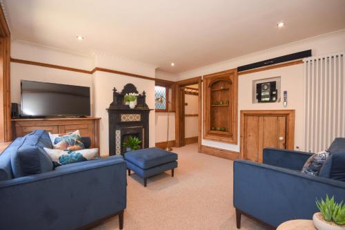 a living room with two blue couches and a fireplace at Unique period one bedroom house in Colchester in Colchester