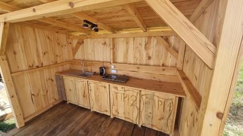 an interior of a wooden cabin with a kitchen in it at Tipi Bieszczady Puchary in Hoczew