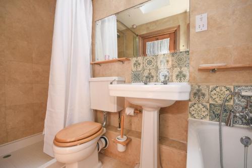 y baño con aseo, lavabo y espejo. en Unique period one bedroom house in Colchester, en Colchester
